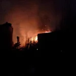 Нічна пожежа на промисловому обєкті з яскравим помаранчевим полумям і димом