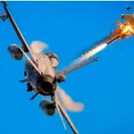 Истребитель F-16 запускает ракету, поражающую дрон в голубом небе